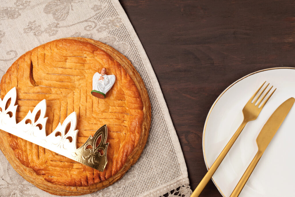 King cake or galette des rois in French. Traditional epiphany pie with golden paper crown and tiny charms