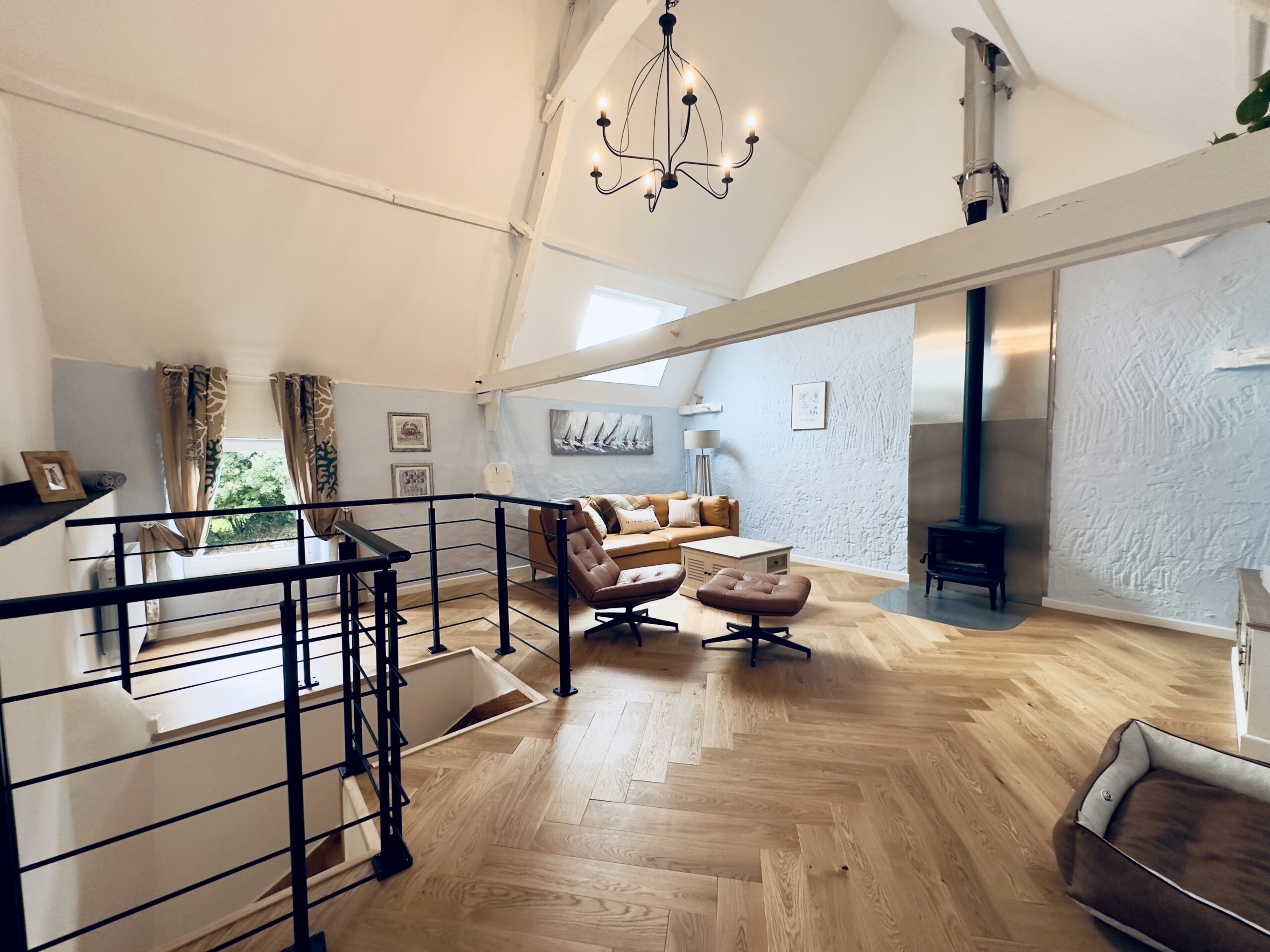 Kamin, Ledersofa, gemütlicher Sessel mit Hocker, Fischgrät-Parkett im Wohnzimmer von La Benoîterie