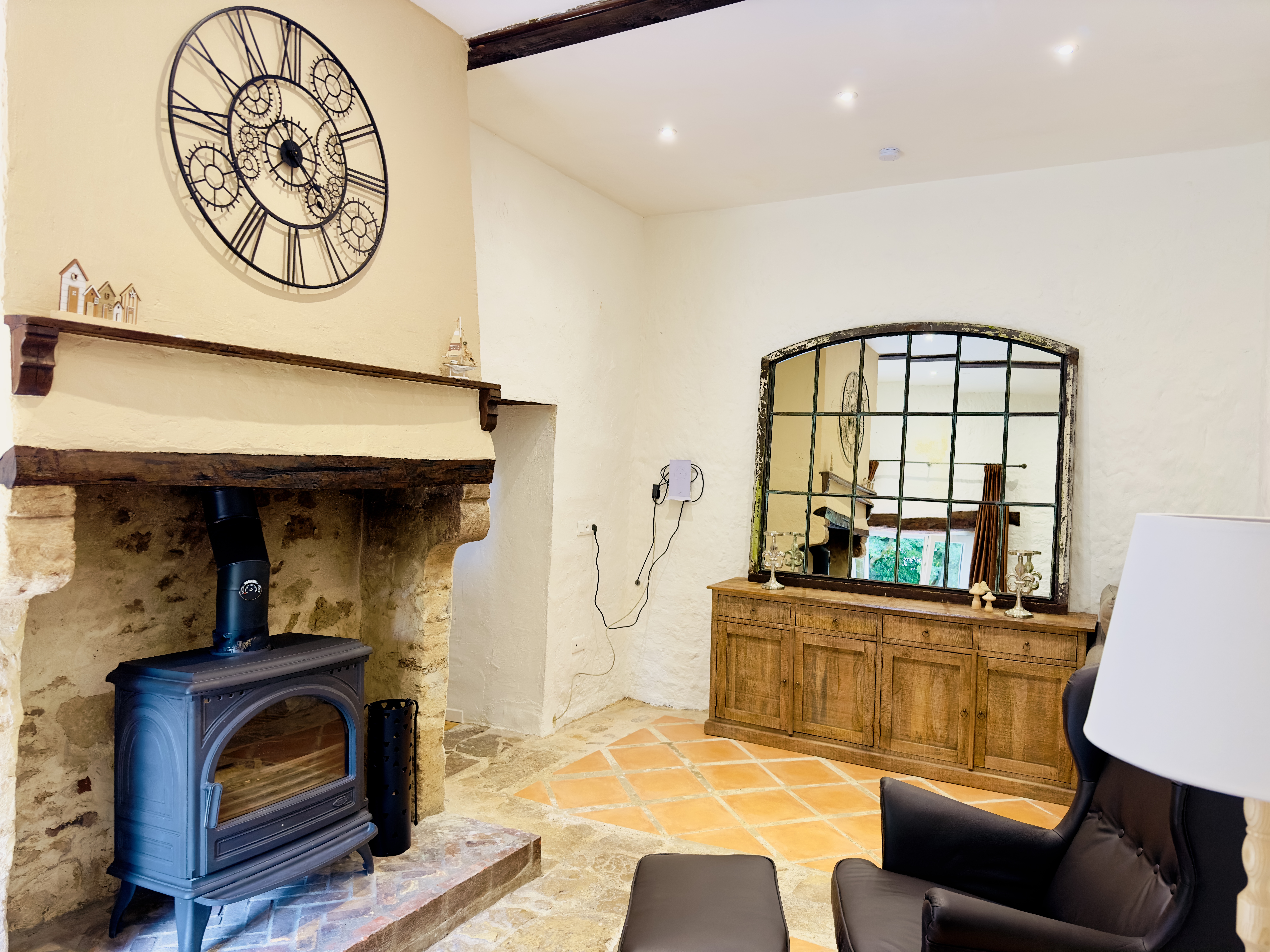 Sitzplatz vor dem Kamin mit Sideboard und großem Spiegel
